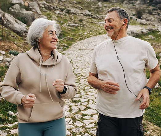 Older couple jogging on a rocky trail