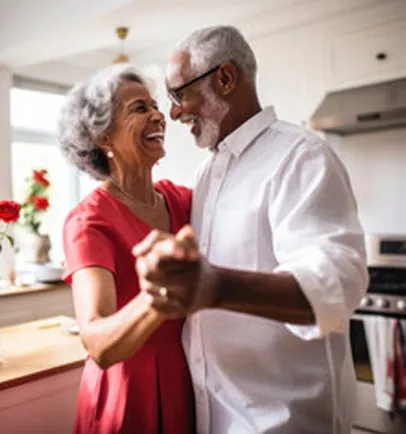 Older couple dancing and laughing in a kitchen
